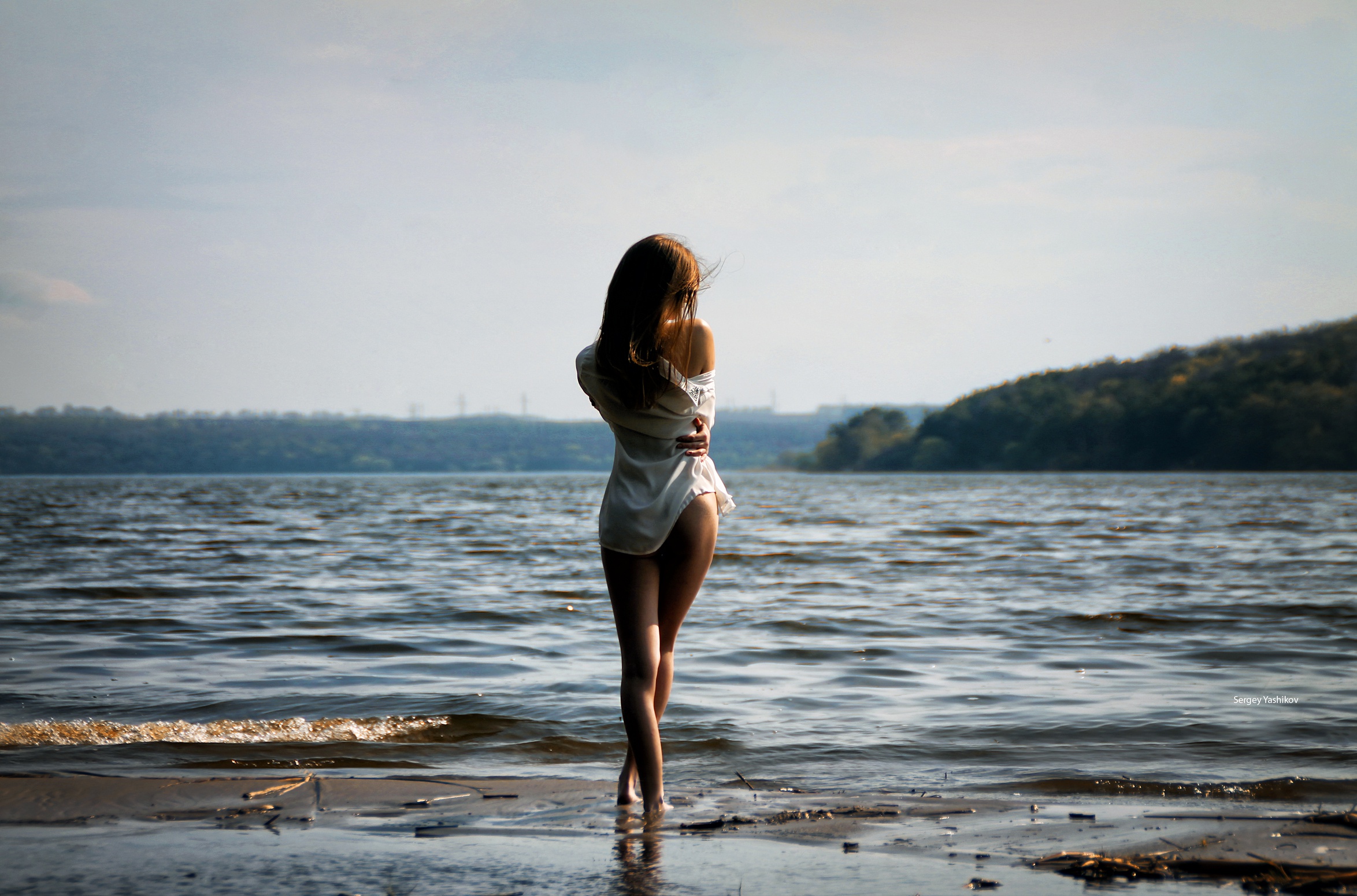 Худенькая девушка позирует у озера
