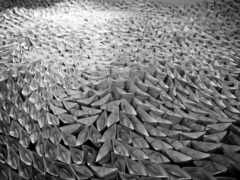 в большой комнате много сложенных бумажных лодок