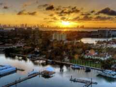 вид на город с пристанью для яхт и закатом