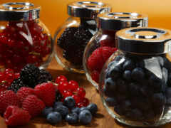 на столе четыре банки ягод и черники