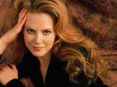 блондинка с длинными волосами позирует для фото в черной куртке