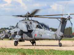 есть много военных вертолетов, которые стоят на взлетно-посадочной полосе