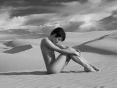 женщина, сидящая на песке в пустыне