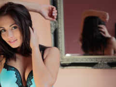 женщина в синем лифчике и черных трусиках позирует перед зеркалом