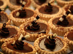 есть много шоколадных кексов с шоколадной глазурью на тарелке