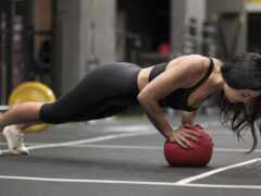 женщина в черном топе толкает вверх на красный шар