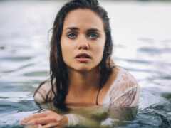 есть женщина в воде с повязкой на груди