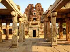 женский вид на каменное сооружение со столбами и дверным проемом