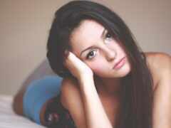 женщина лежит на кровати с головой на руках