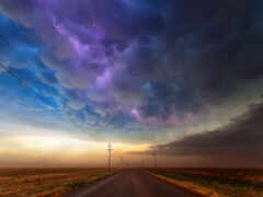 женщина видит дорогу с линиями электропередач и шторм на расстоянии