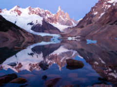 горы, отраженные в озере с камнями и валунами