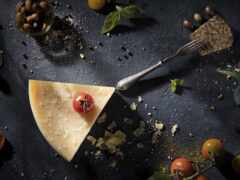 есть кусок сыра с помидором на нем