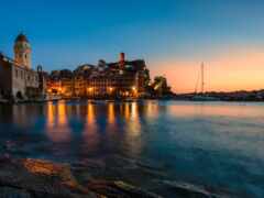 вид на город с башней с часами и водоемом