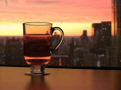 на столе перед окном стоит стакан чая