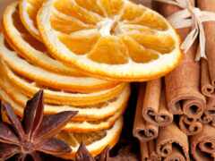 на столе много корицы и апельсиновых ломтиков