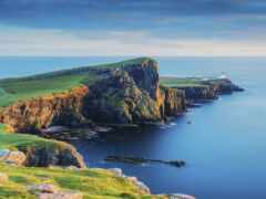 женский вид на маяк на скалистом утесе с видом на океан