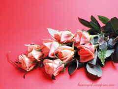 на красной поверхности есть куча розовых роз