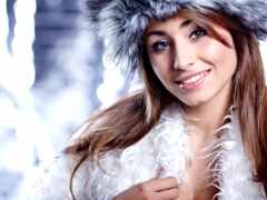 женщина в меховой шляпе и белом пальто улыбается