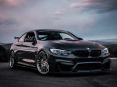 женщина черная bmw m4 с красивой позицией в пасмурный день