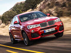 красный bmw suv едет по дороге