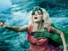 блондинка в розовом платье с зеленым русалочным хвостом в воде