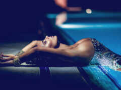 женщина, лежащая на краю бассейна в сверкающем платье