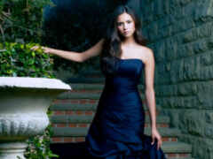 женщина в голубом платье, стоящая рядом с каменной урной