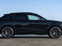 черная женщина-сув припарковалась на пляже недалеко от океана