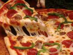 кто-то разрезает пиццу с лопаткой сыра и пепперони