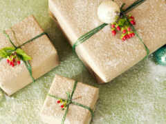 три завернутых подарка с зелеными и красными луками и украшениями