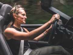 женщина за рулем автомобиля с рулем и черным сиденьем