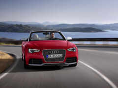 арафированный красный audi roadster едет по извилистой дороге