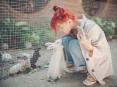 есть женщина, которая гладит белого кролика