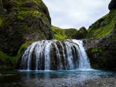 женский водопад в каньоне с мховыми скалами и водой