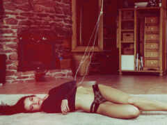 на полу лежит женщина с веревкой в руке