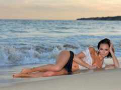 женщина в белом бикини, лежащая на пляже