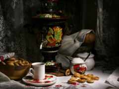 есть стол с миской пончиков и чашкой кофе