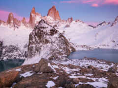 горы со снегом на них и озеро посредине