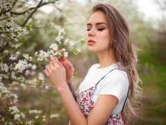 женщина, пахнущая цветком в поле цветов