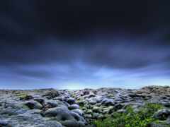 существует большое поле скал и травы под облачным небом