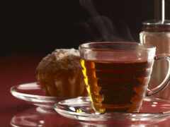 есть чашка чая и тарелка выпечки на столе