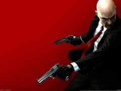 мужчина в костюме держит в руке два пистолета