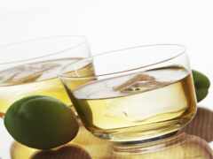 на столе два стакана алкоголя и два зеленых яблока