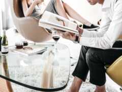 мужчина и женщина сидят на диване и читают книгу