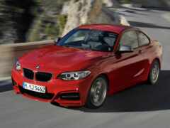 красный автомобиль bmw, едущий по дороге