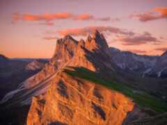 горы с зеленым склоном и несколькими облаками в небе