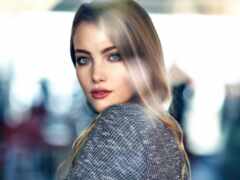 блондинка с голубыми глазами и длинными волосами в сером свитере