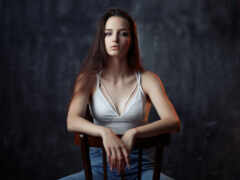 женщина, сидящая в кресле с руками на коленях