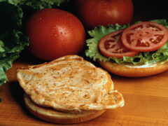 есть сэндвич с салатом, помидорами и сыром на нем