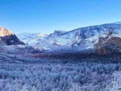 горы, покрытые снегом и деревьями, с поездом, проходящим через них